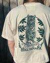 Person wearing a t-shirt with a tiger design and 'Girl Dinner' text on the back.